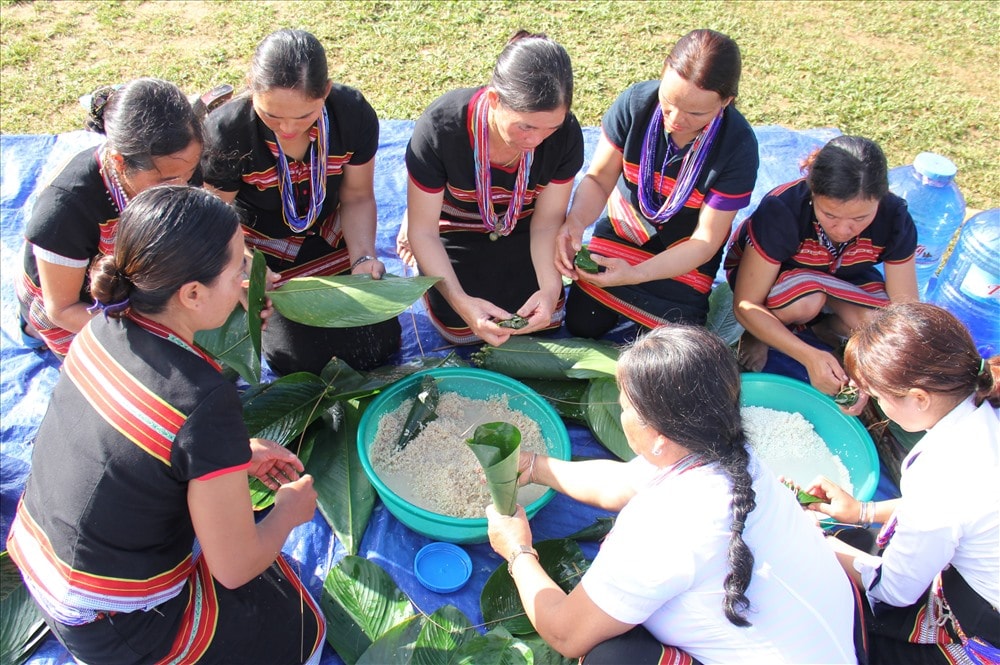 Phụ nữ Bh’noong cùng nhau gói bánh koát. Loại bánh này được làm từ gạo baton quý hiếm, nguyên liệu chính trong lễ hội tết mùa. Ảnh: ALĂNG NGƯỚC