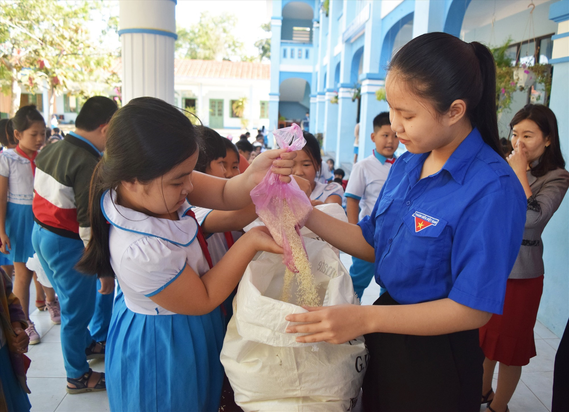 Học sinh ủng hộ gạo cho chương trình hủ gạo tình thương do đoàn xã Tam Nghĩa phát động - Ảnh: THÁI CƯỜNG