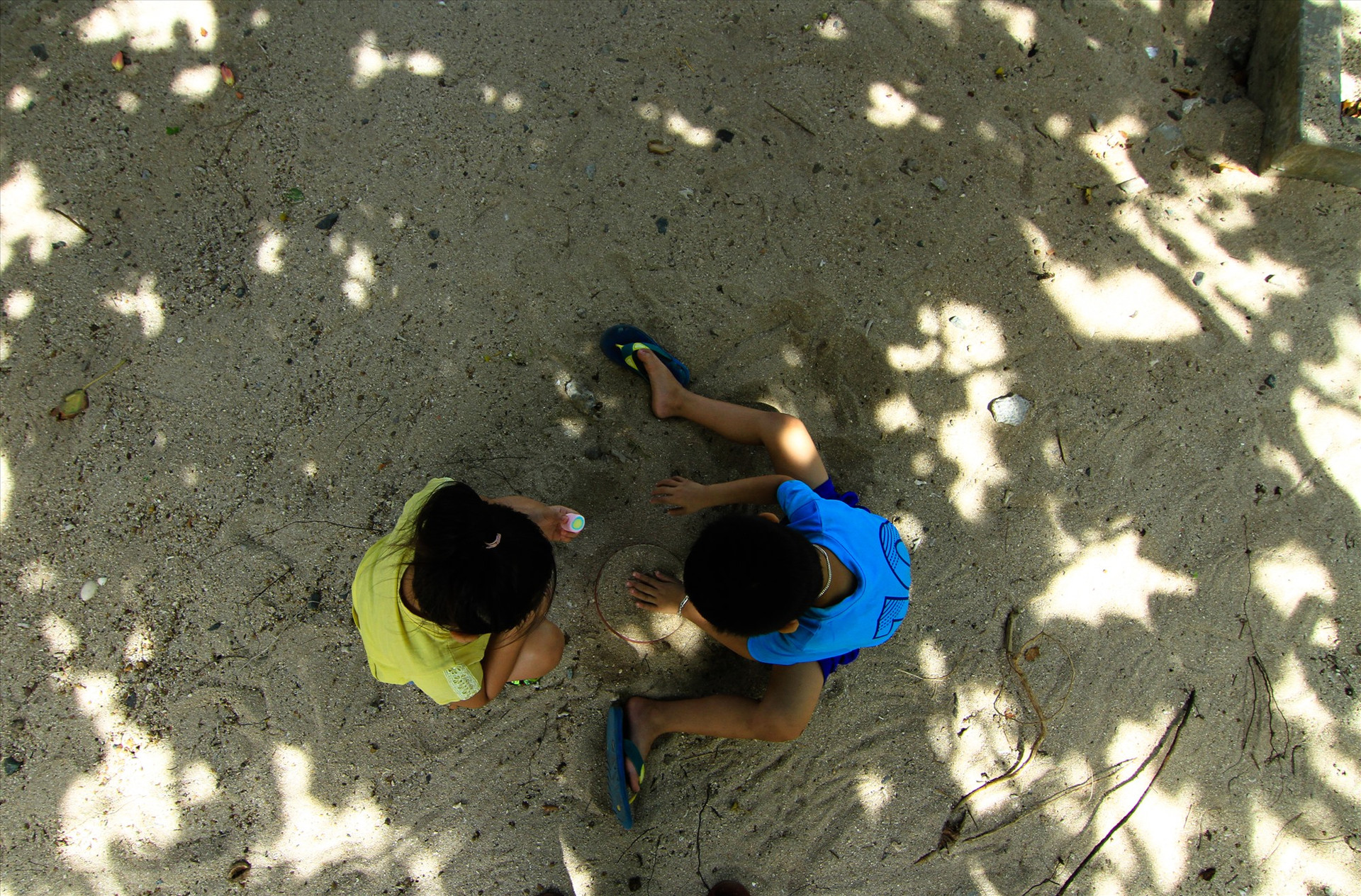 Hai đứa trẻ chơi dưới bóng mát cây tra già trên đảo. Ảnh: T.C