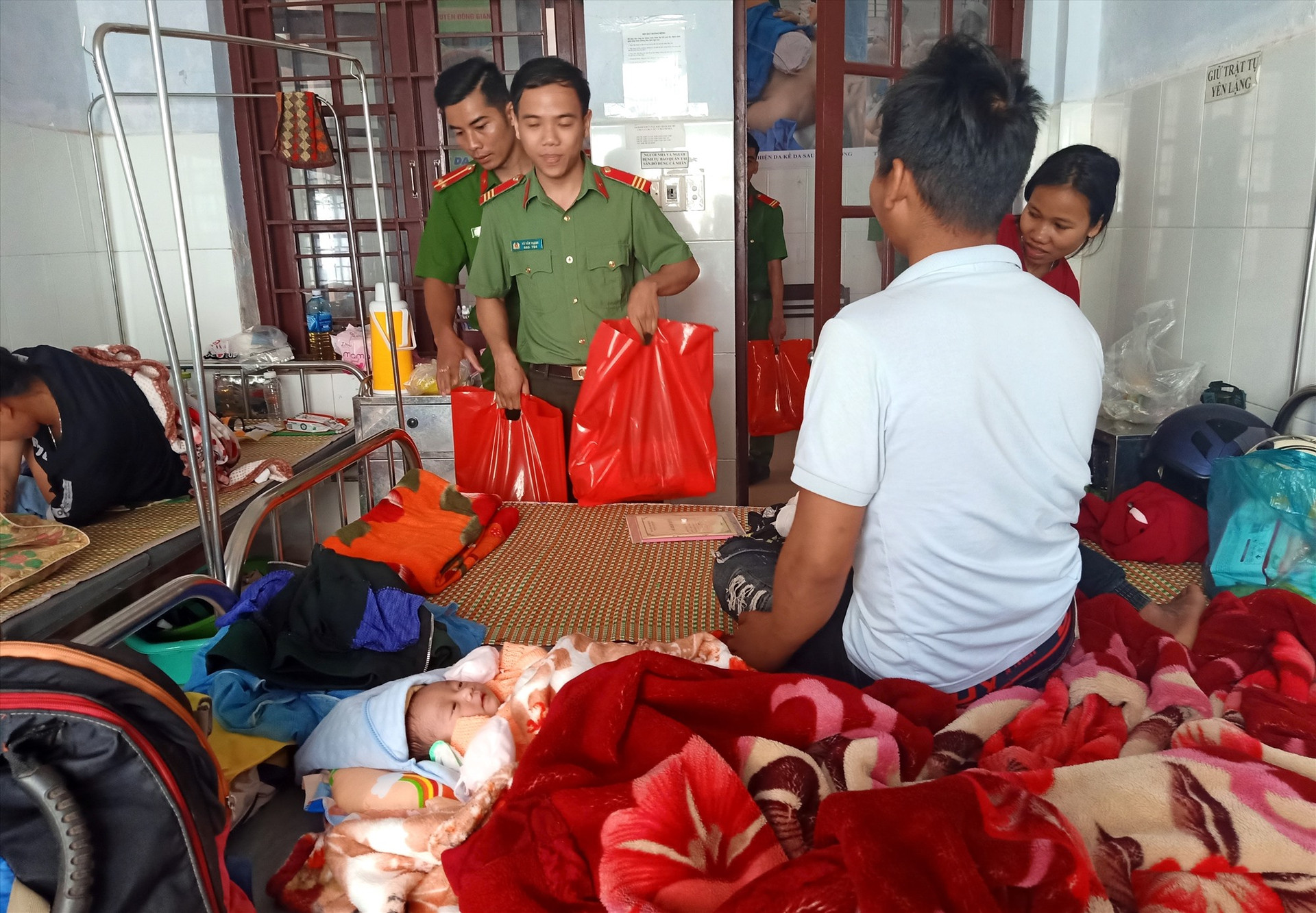 Các cán bộ, chiến sĩ trao quà tết động viên người nhà có em bé vừa chào đời tại bệnh viện. Ảnh: Đ.N