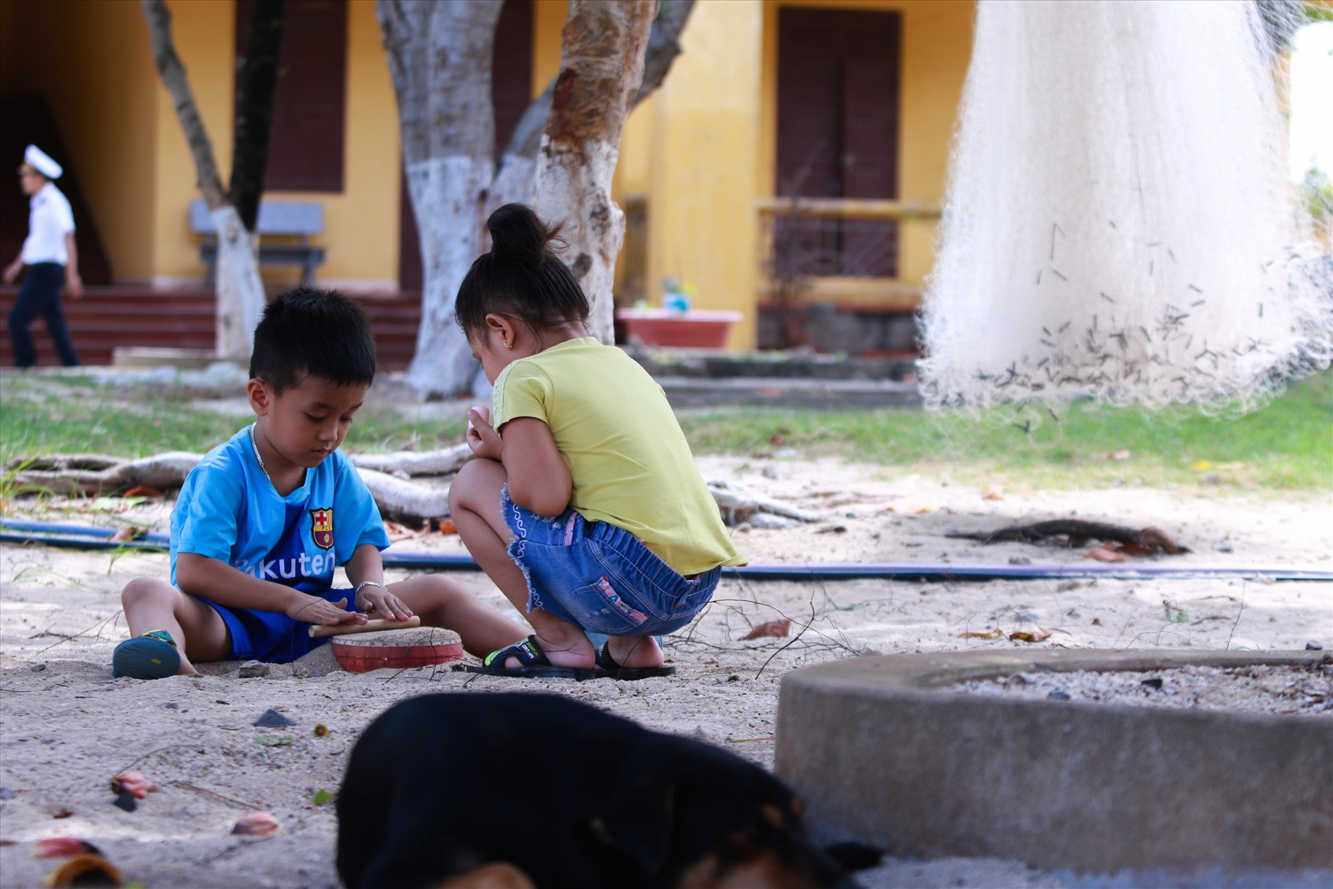 Bảo Nam và Mẫn Nhi (học mẫu giáo Trường Tiểu học Sinh Tồn) chơi dưới bóng mát cạnh khu nhà ở của gia đình mình trên đảo. Ảnh: T.C