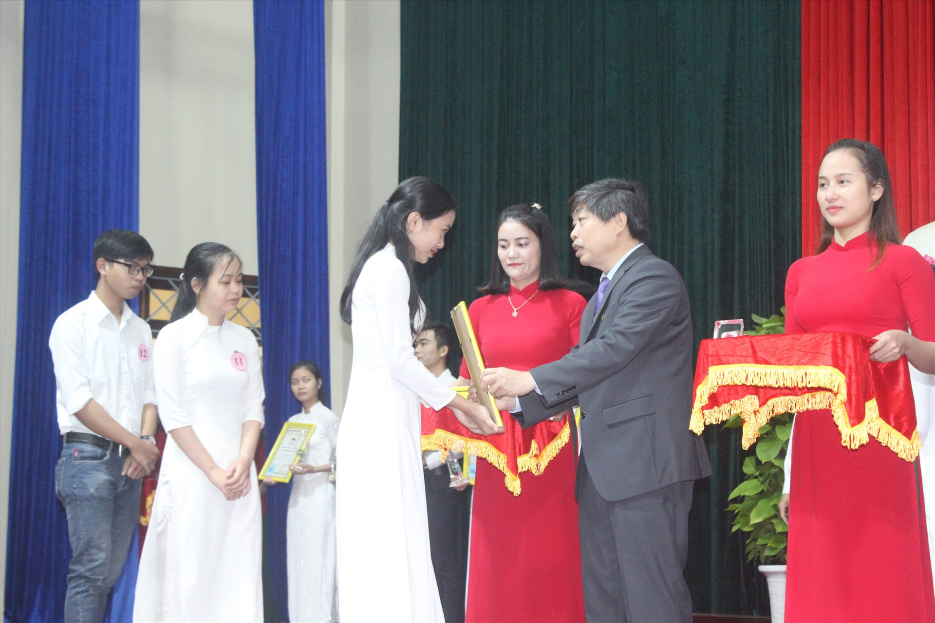 Chủ tịch UBND huyện Tiên Phước trao chứng nhận cho sinh viên xuất sắc. Ảnh: D.L
