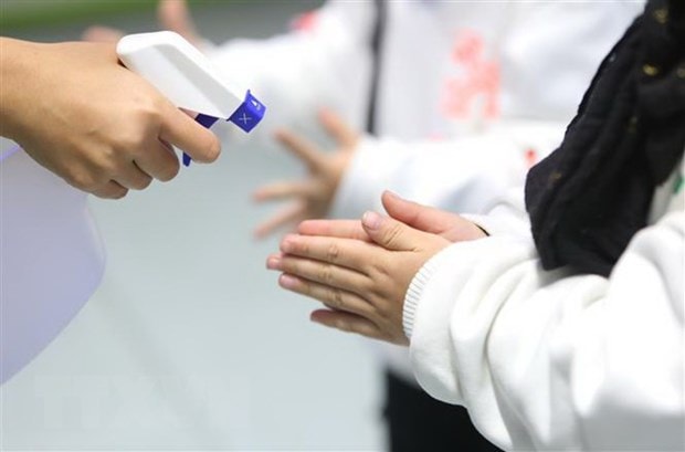 Nhân viên khu vui chơi của một trung tâm thương mại kiểm tra nhiệt độ và tẩy trùng vệ sinh để phòng ngừa virus corona. (Ảnh: Thành Đạt/TTXVN)
