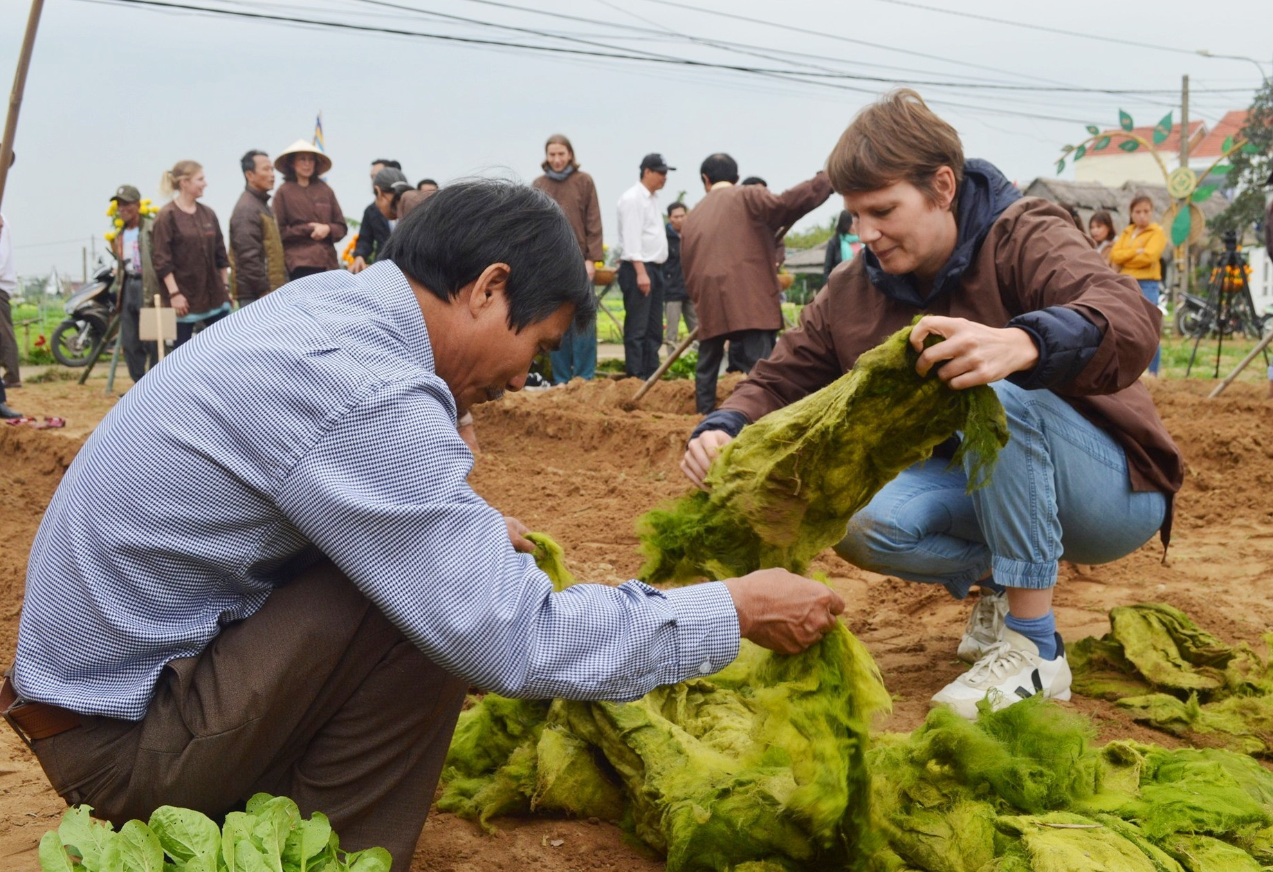 Du khách nước ngoài tham gia cuộc thi xới đất cấy cải