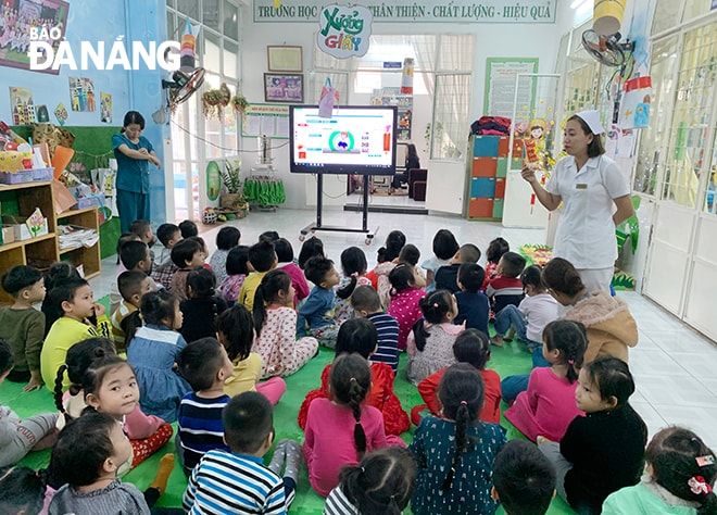 Trường mầm non Phương Lan (quận Thanh Khê) hướng dẫn cách đeo khẩu trang cho các cháu học sinh. Ảnh: NGỌC PHÚ