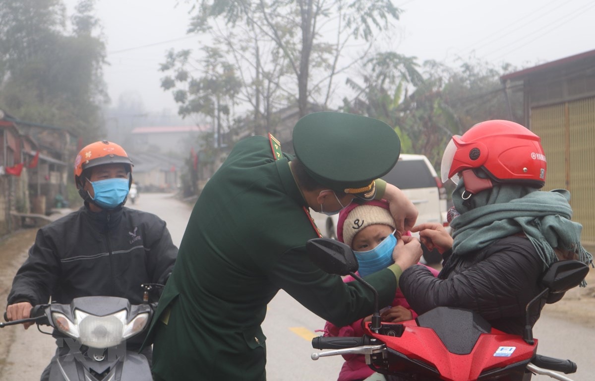 Bộ đội Biên phòng Đồn Biên phòng Cửa khẩu Trà Lĩnh phát khẩu trang miễn phí cho người dân. (Ảnh: Chu Hiệu/TTXVN)