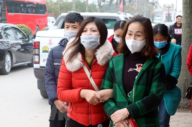 Nhiều du khách về đền Trần (Nam Định) du xuân, dâng hương các vị Vua nhà Trần đã sử dụng khẩu trang y tế để phòng, chống dịch bệnh viêm đường hô hấp cấp do chủng mới của virus Corona. (Ảnh: Văn Đạt/TTXVN)