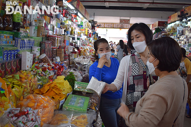 Tiểu thương và du khách chủ động mang khẩu trang khi giao dịch (ảnh chụp tại chợ Hàn chiều 3-2). Ảnh: KHÁNH HÒA