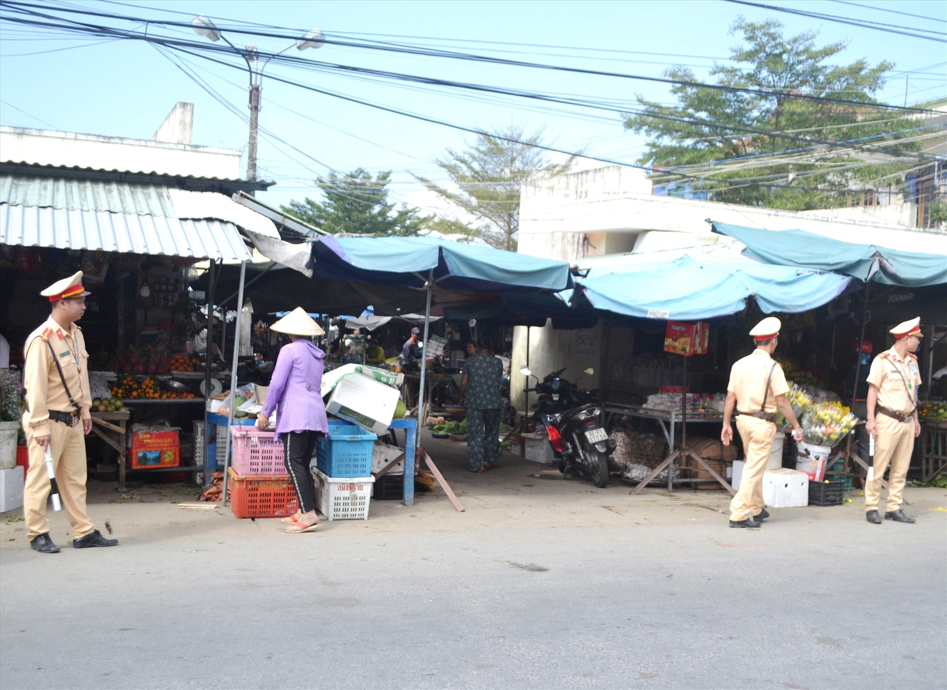 Cảnh sát giao thông Đại Lộc kiểm tra, nhắc nhở người dân buôn bán tại chợ Quảng Huế không lấn chiếm lòng đường ĐT609B. Ảnh: C.T