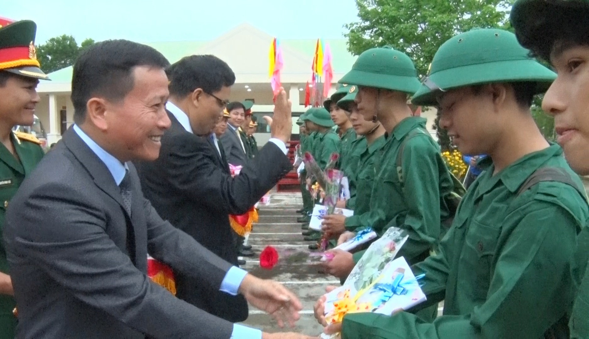 Đồng chí Thái Bình -Bí thư huyện ủy Nông Sơn tăng hoa và động viên thanh niên lên đường. Ảnh M.T