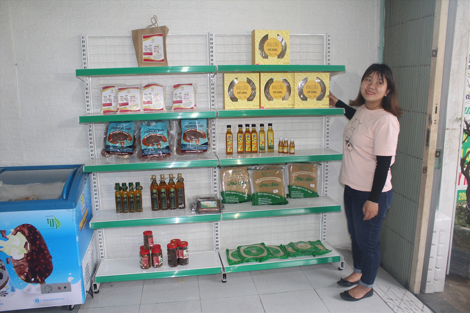 Chị Sang và các sản phẩm OCOP trưng bày tại cửa hàng. Ảnh: VĂN PHIN