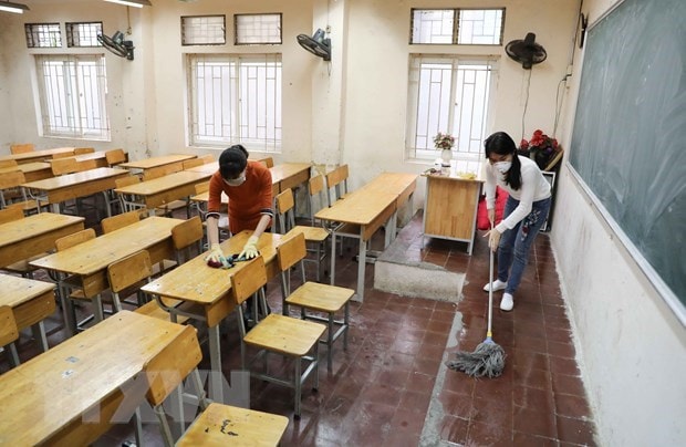 Giáo viên Trường THPT Trương Định, Hà Nội tiến hành vệ sinh, khử khuẩn lớp học lần 2 trong ngày 8-2. (Ảnh: Thanh Tùng/TTXVN)