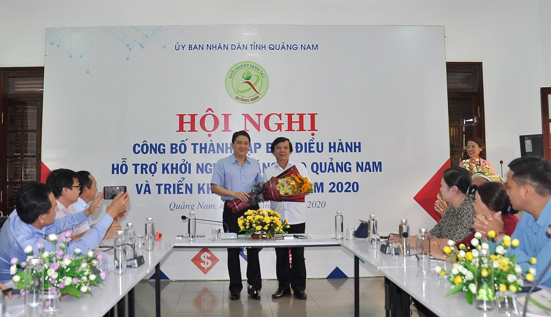 Ông Phạm Ngọc Sinh - Phó Giám đốc Sở KH-CN thay mặt Ban điều hành nhận hoa chúc mừng từ Phó Chủ tịch UBND tỉnh Trần Văn Tân. Ảnh: VINH ANH