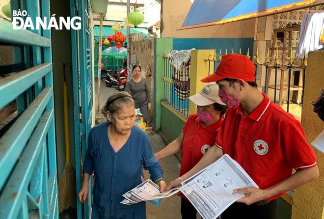 Hội viên Hội Chữ thập đỏ đến tận nhà người dân phát tờ rơi tuyên truyền phòng, chống Covid-19. (Ảnh từ facebook nhân vật)