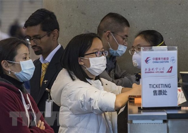 Hành khách đeo khẩu trang đề phòng lây nhiễm COVID-19 tại sân bay quốc tế Los Angeles, bang California, Mỹ. (Ảnh: AFP/TTXVN)