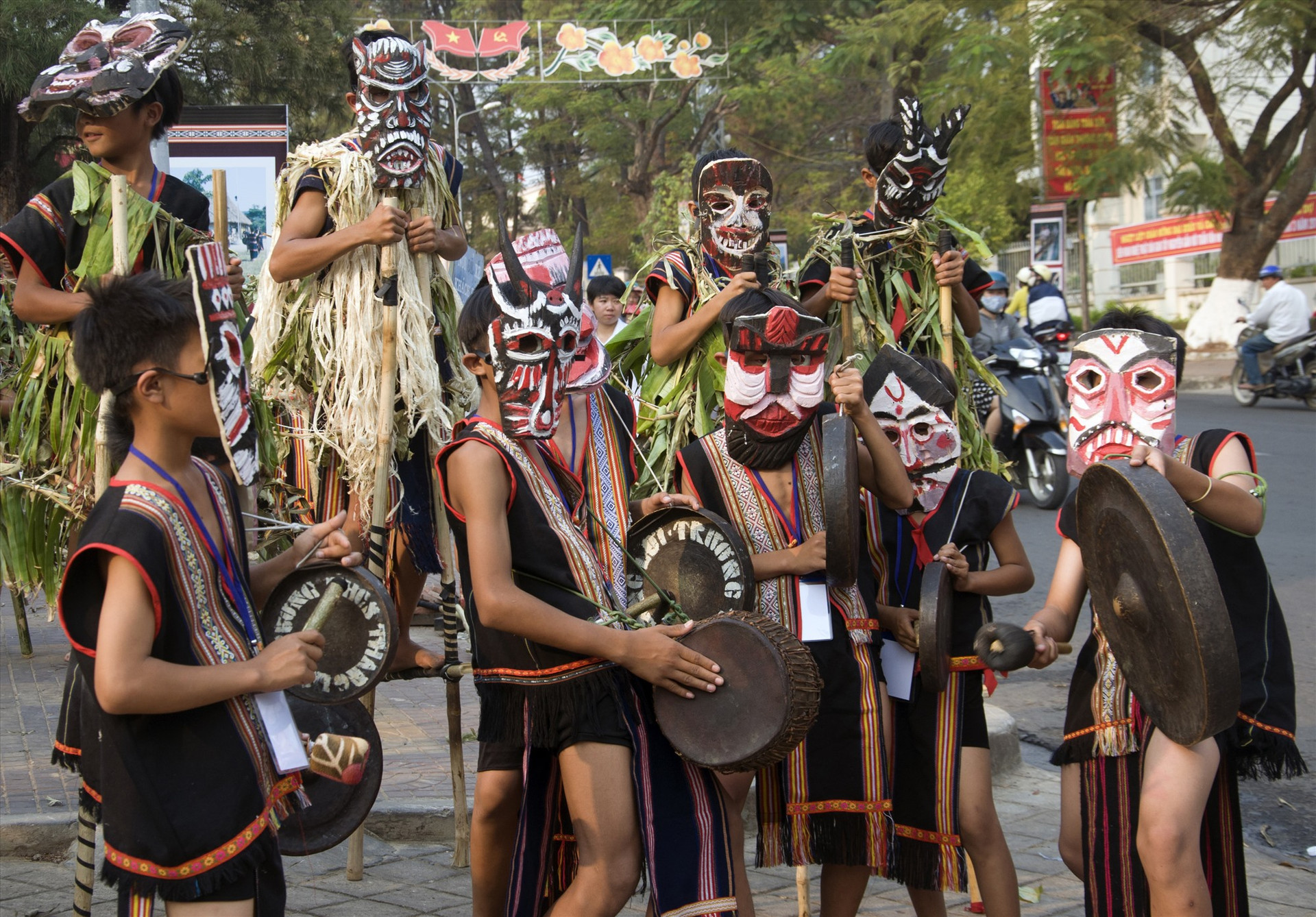 Các nghệ nhân dân tộc Ba Na đeo mặt nạ gỗ trong lễ hội đường phố.