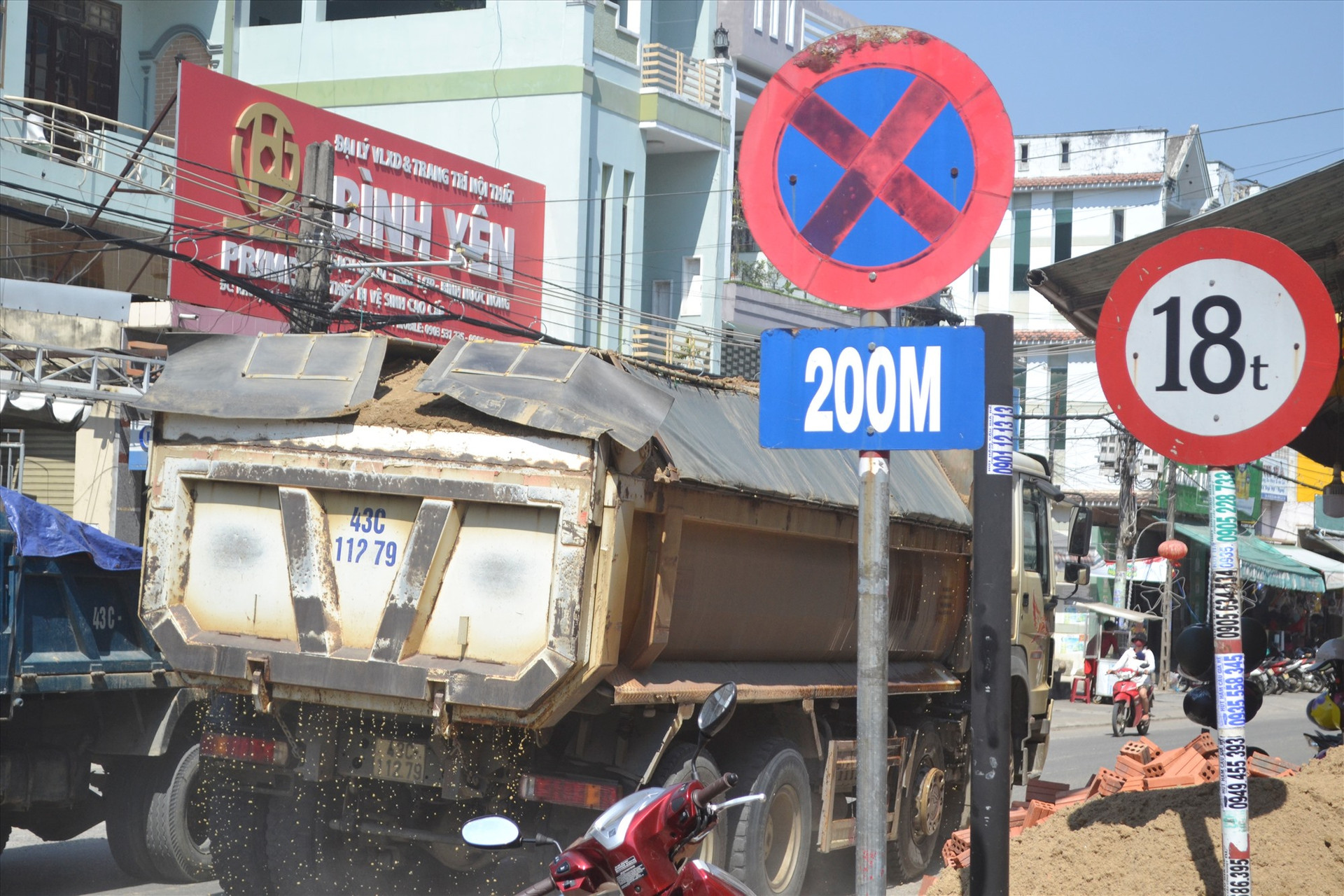 Bất chấp biển báo hạn chế tải trọng, tài xế xe tải chở cát ngang nhiên lưu thông trên đường Huỳnh Ngọc Huệ vào trưa ngày 15.2. Ảnh: N.B