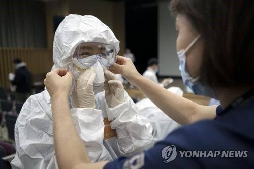 Trang bị đồ bảo hộ cho nhân viên y tế. (Nguồn: Yonhap)