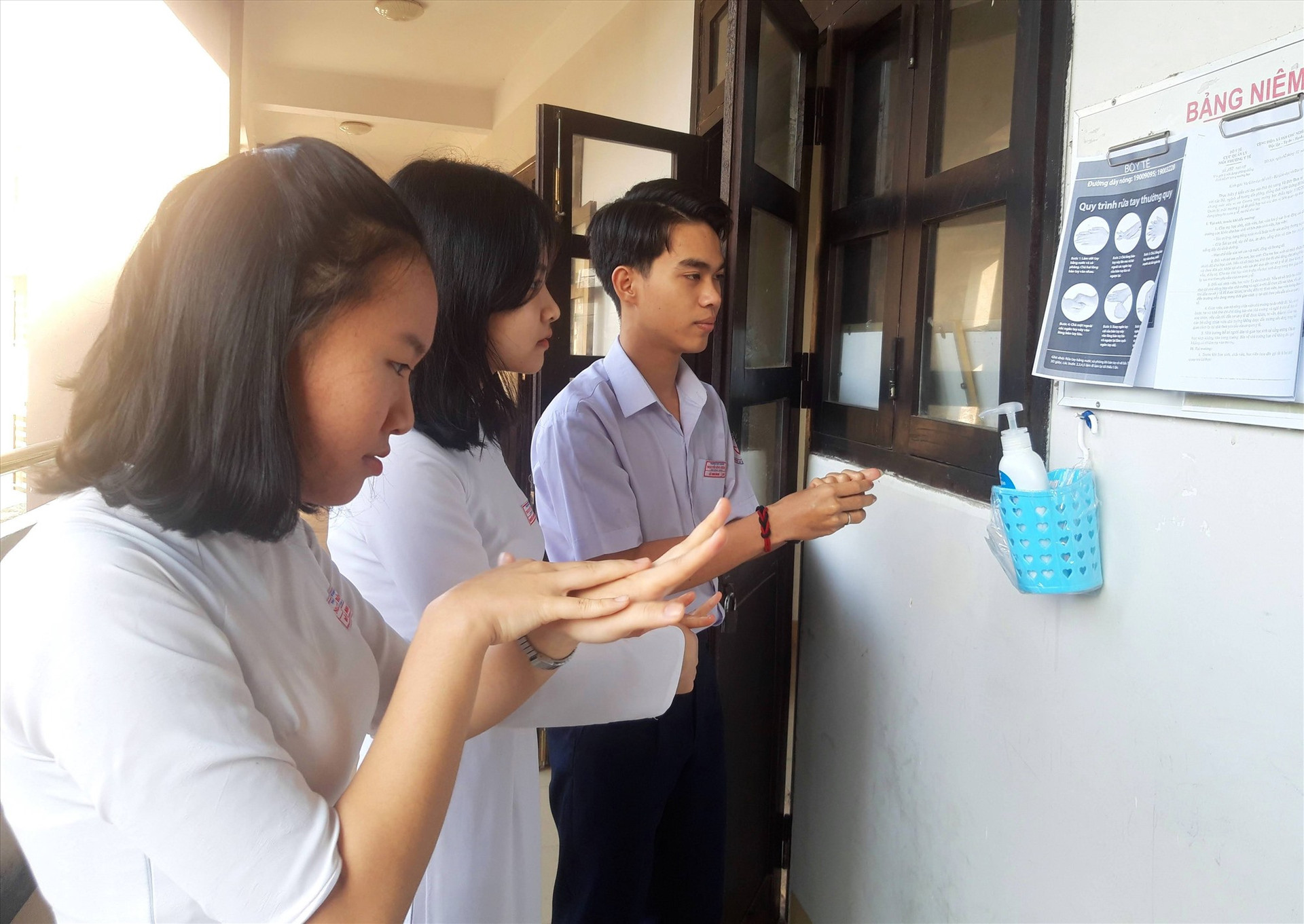 Học sinh Trường THPT chuyên Nguyễn Bỉnh Khiêm rửa tay sát khuẩn trước khi vào lớp. Ảnh: H.Q