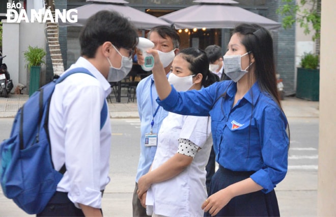 Đoàn Thanh niên Trường THPT Trần Phú đo thân nhiệt cho học sinh. Ảnh: NGỌC PHÚ