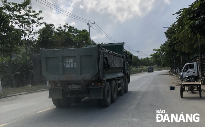 Xe ben vận chuyển đất, đá trên đường ĐT 602. Ảnh: HÒA KHÁNH