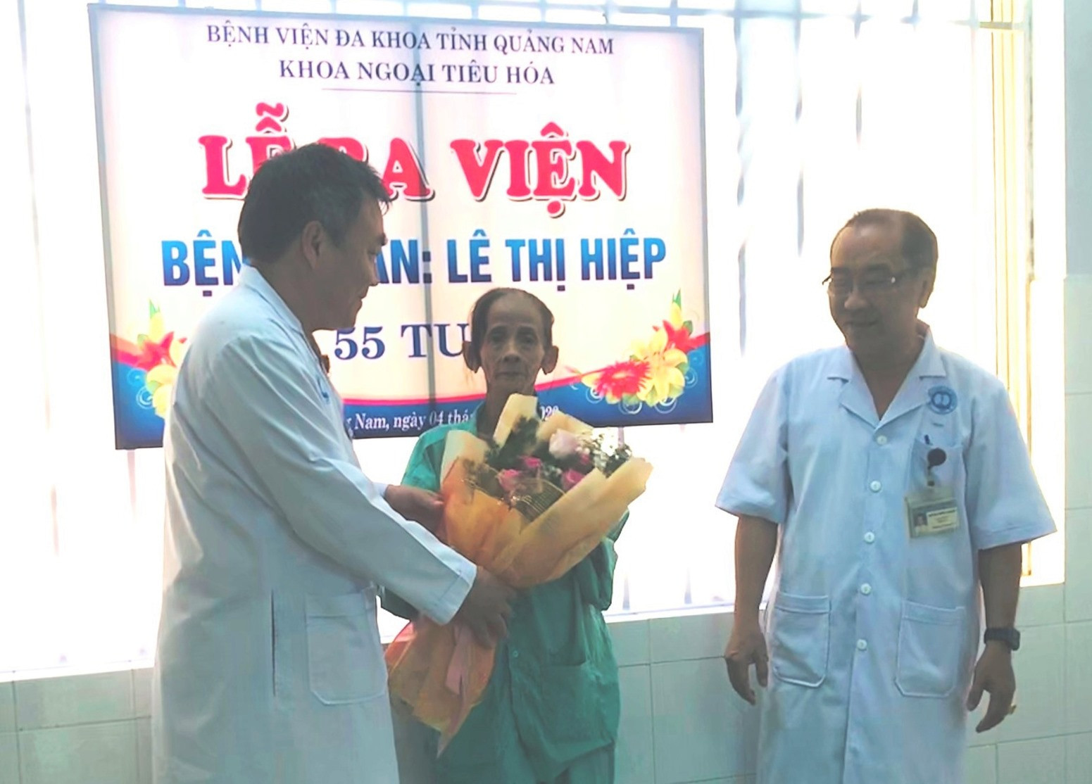 Giám đốc BVĐK Quảng Nam (trái) tặng hoa và trao giấy ra viện cho bệnh nhân. Ảnh: C.N