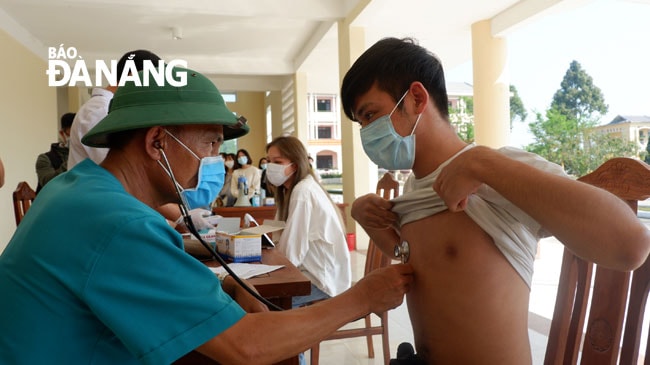 Nhân viên y tế kiểm tra nhịp tim, phổi cho công dân trước khi ra về. Ảnh: PHAN CHUNG