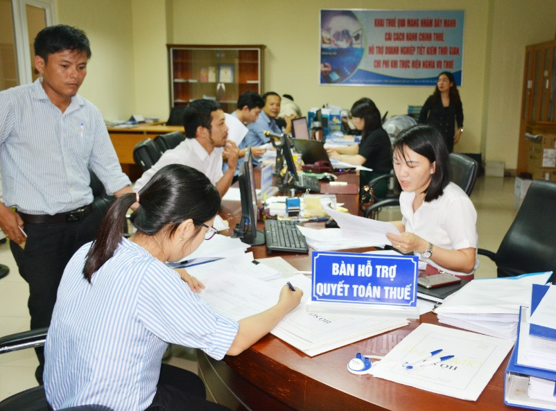Cán bộ Cục Thuế Quảng Nam hỗ trợ về giải quyết thủ tục nộp thuế. Ảnh: V.DŨNG