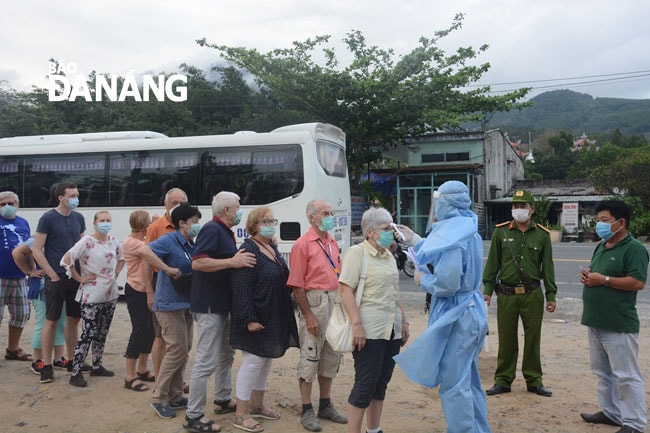 Lực lượng chức năng kiểm tra thân nhiệt du khách tại khu vực phía Nam đèo Hải Vân. Ảnh: Công Lê