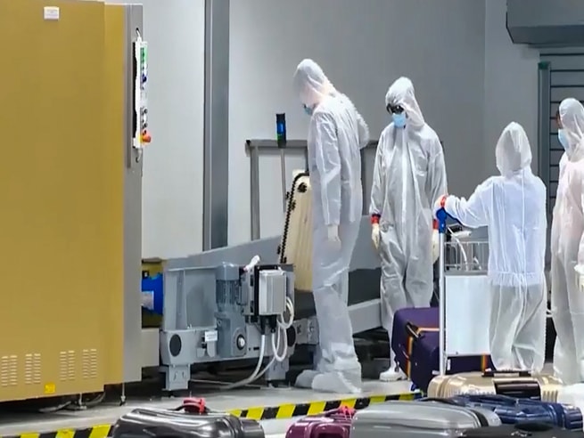 Các nhân viên an ninh kiểm tra lại hành lý trước khi bàn giao cho hành khách.