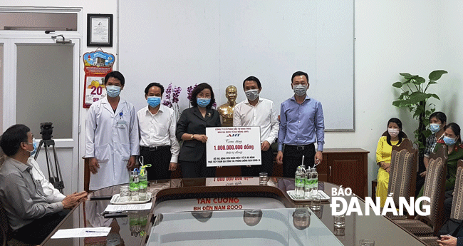 Đại diện Sở Y tế tiếp nhận 1 tỷ đồng hỗ trợ từ Công ty AHT. Ảnh: PHAN CHUNG