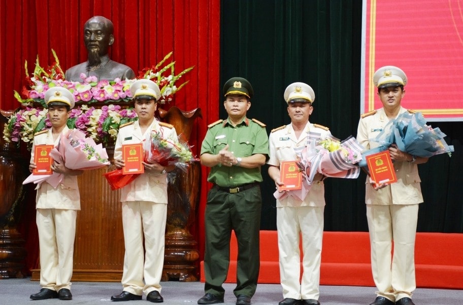 Đại tá Huỳnh Sông Thu, PGĐ Công an tỉnh trao quyết định và tặng hoa chúc mừng cho các đồng chí nhận nhiệm vụ mới.