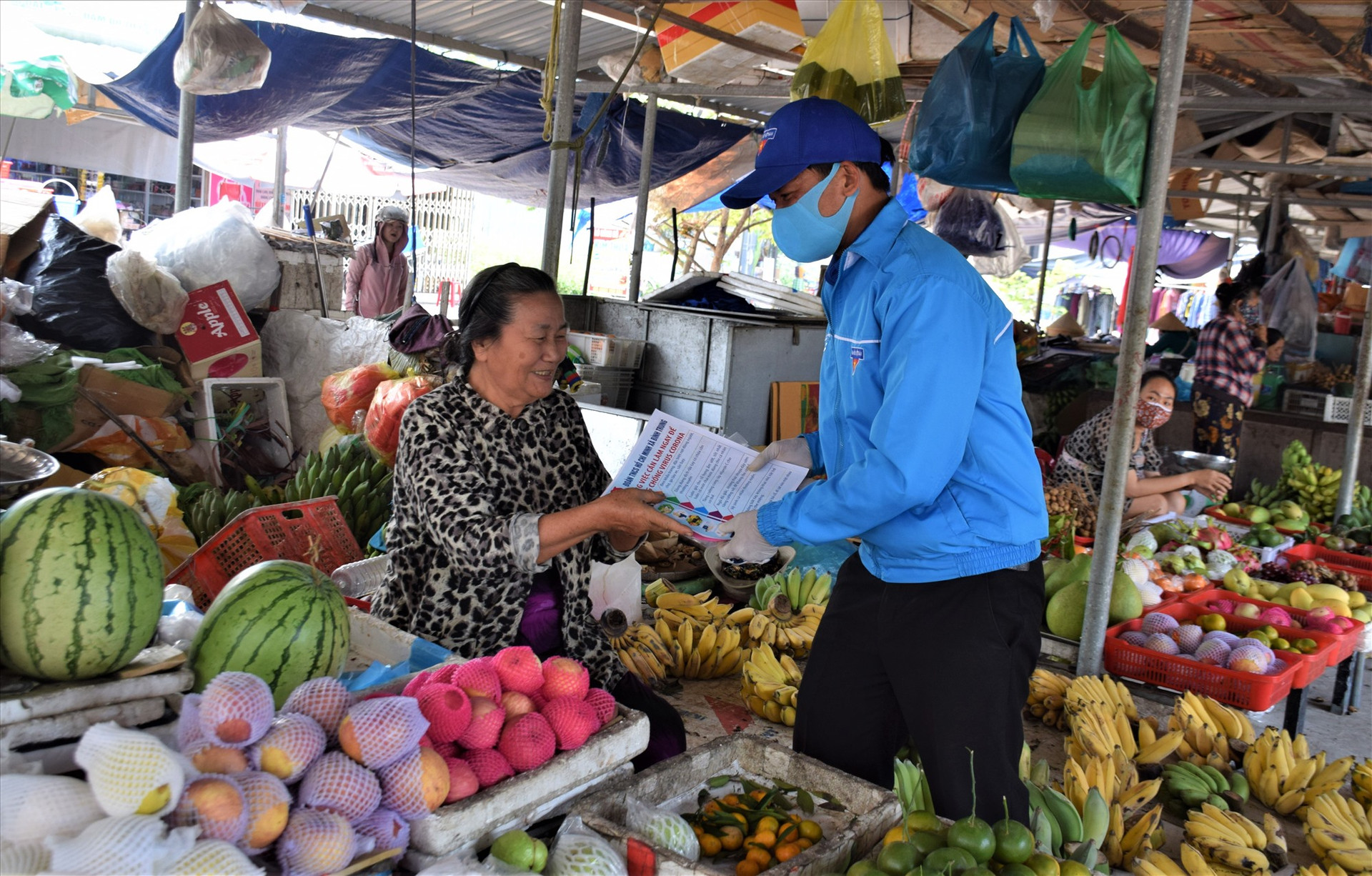 Cán bộ đoàn thanh niên xã Bình Trung, huyện Thăng Bình, phát tờ rơi và tuyên truyền cho tiểu thương tại chợ Kế Xuyên nên đeo khẩu trang tại những nơi công cộng hoặc đông người để phòng chống dịch bệnh Covid-19: Ảnh: THANH THẮNG