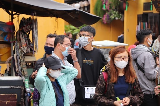 Tourists in Hoi An ancient town with medical masks