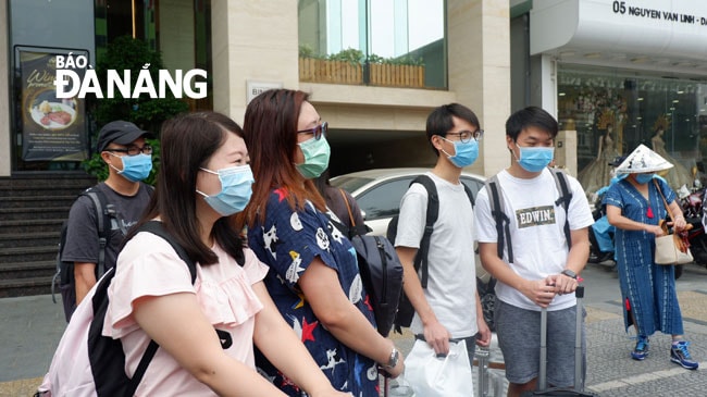 Các du khách chờ phương tiện vận chuyển ra Sân bay để về nước. Ảnh: PHAN CHUNG