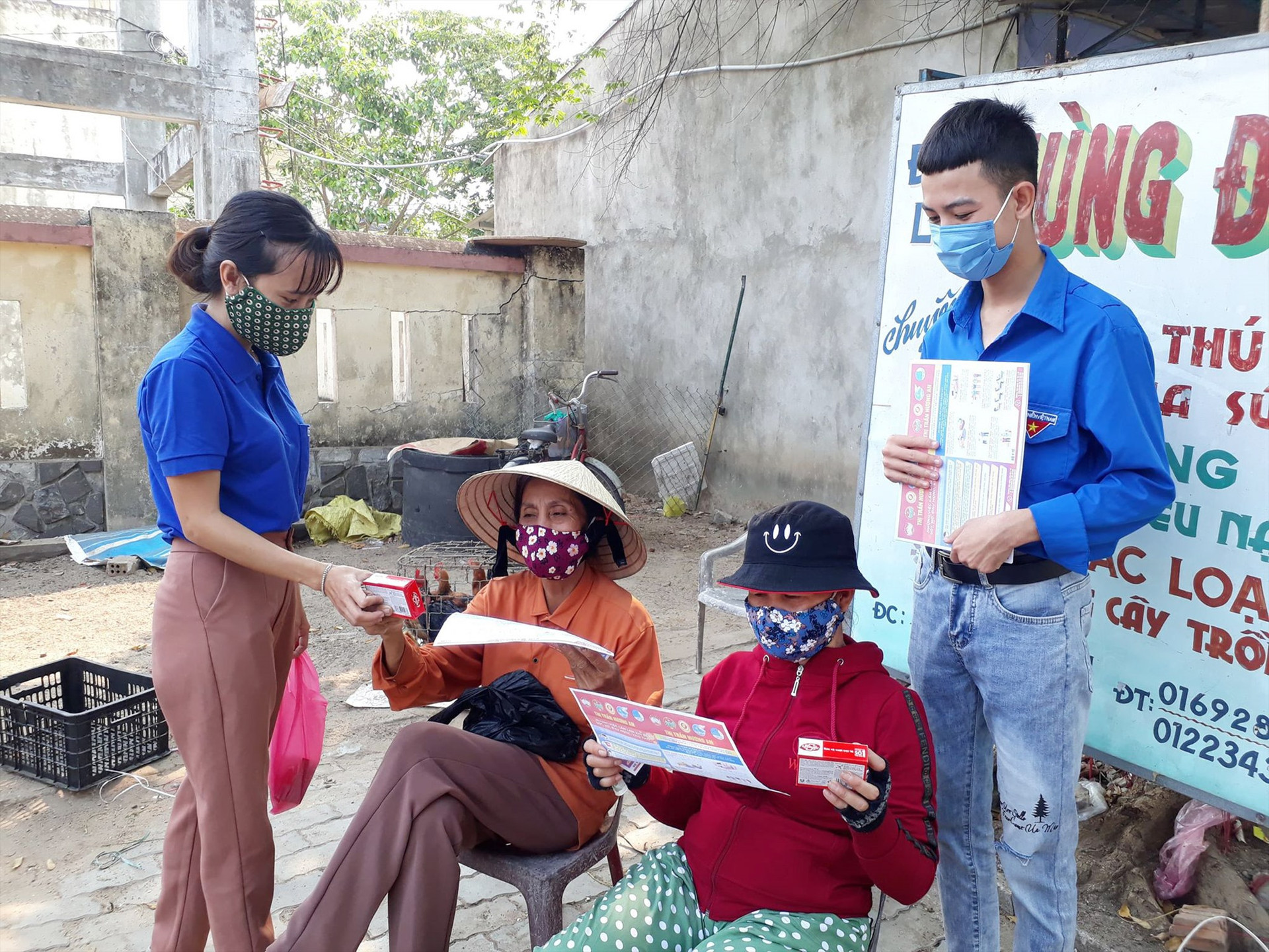 Đoàn viên thanh niên thị trấn Hương An cấp phát tờ rơi hướng dẫn các biện pháp phòng chống dịch bệnh Covid-19 cho người dân. Ảnh: T.P