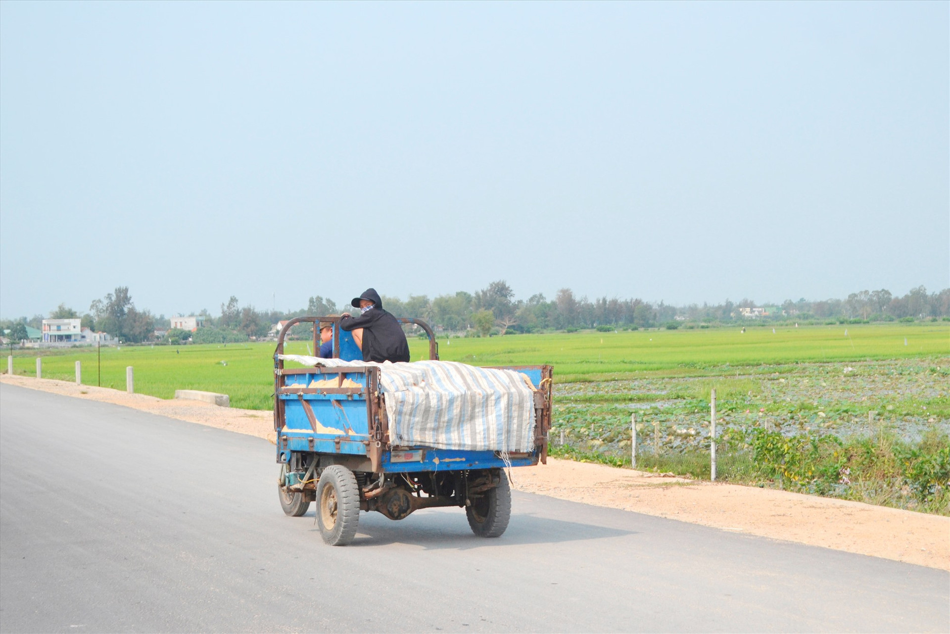 Xe 3 bánh (xe lôi) dùng chở hàng, nhưng kèm chở người trên một tuyến đường tại xã Bình Đào (Thăng Bình). Ảnh: K.K