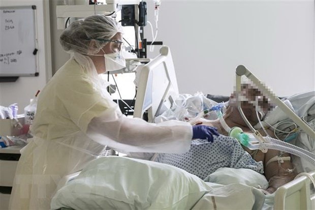 Nhân viên y tế điều trị cho bệnh nhân nhiễm Covid-19 tại bệnh viện Louis Pasteur ở Colmar, Pháp ngày 26-3-2020. (Ảnh: AFP/TTXVN)