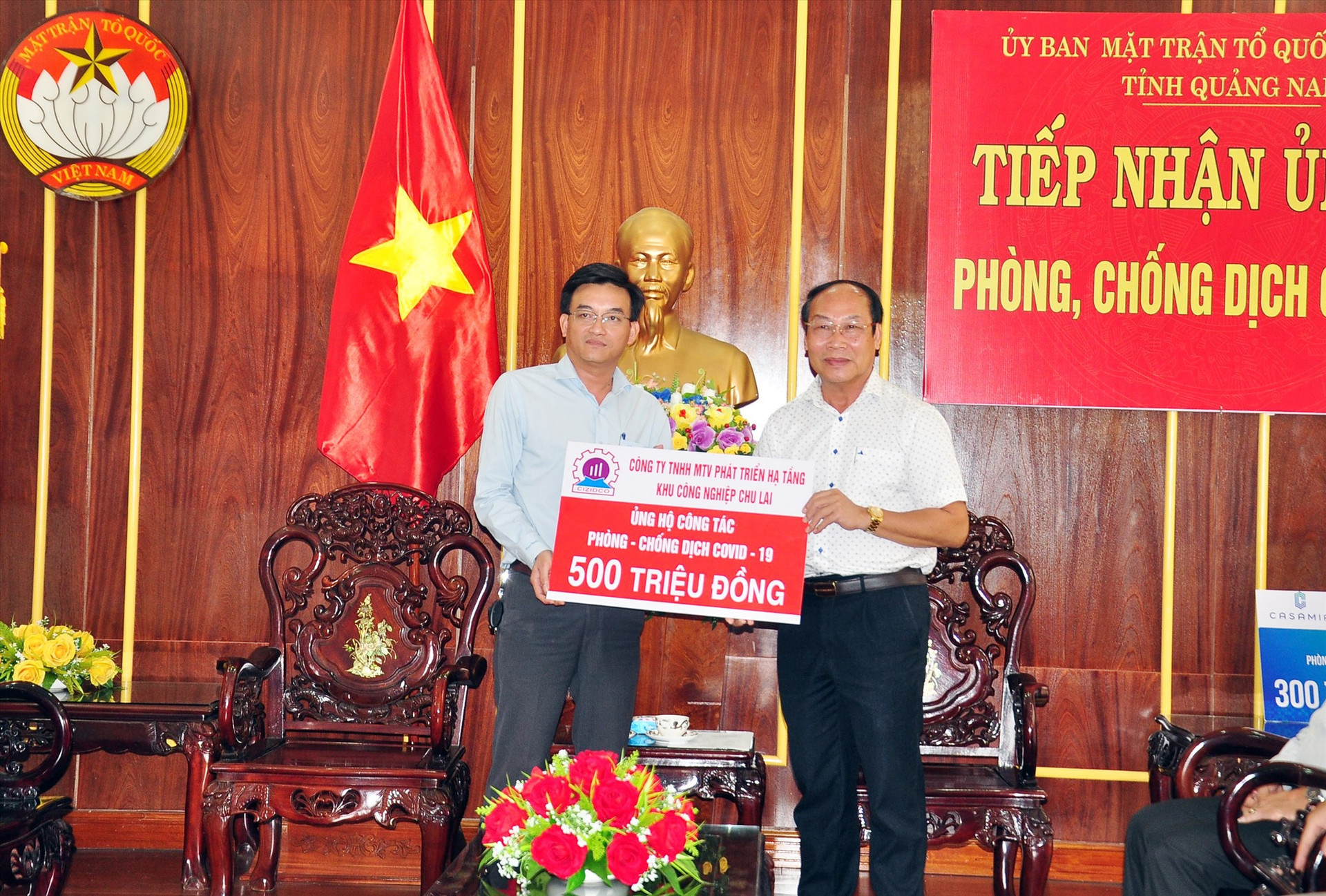 Chủ tịch Ủy ban MTTQ Việt Nam tỉnh Võ Xuân Ca (phải) tiếp nhận nguồn hỗ trợ 500 triệu đồng cho công tác phòng chống dịch Covid-19 từ Công ty TNHH MTV Phát triển hạ tầng Khu công nghiệp Chu Lai. Ảnh: VINH ANH
