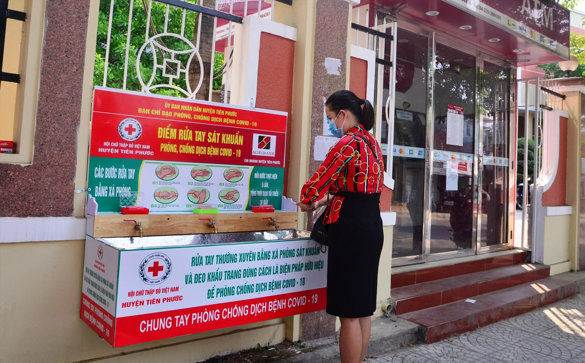 Người dân rửa tay tại các trạm rửa tay giã chiến ở chợ Tiên Kỳ và trạm ATM Chi nhánh Ngân hàng Nông nghiệp & Phát triển Nông thôn huyện Tiên Phước.