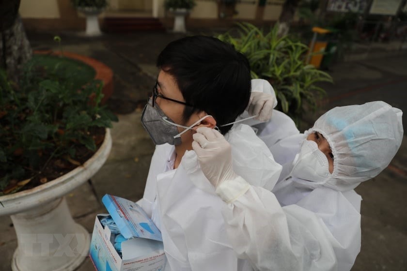 Tổ công tác chuẩn bị các thiết bị cơ sở vật chất phục vụ test nhanh có kết quả trong 10 phút tại điểm trường THCS Đống Đa (Hà Nội) sáng 31/3/2020. (Ảnh: