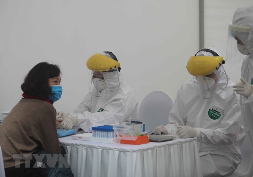 Người dân tới xét nghiệm tại điểm test nhanh ở trường THCS Đống Đa (Hà Nội). (Ảnh: Thanh Tùng/TTXVN)