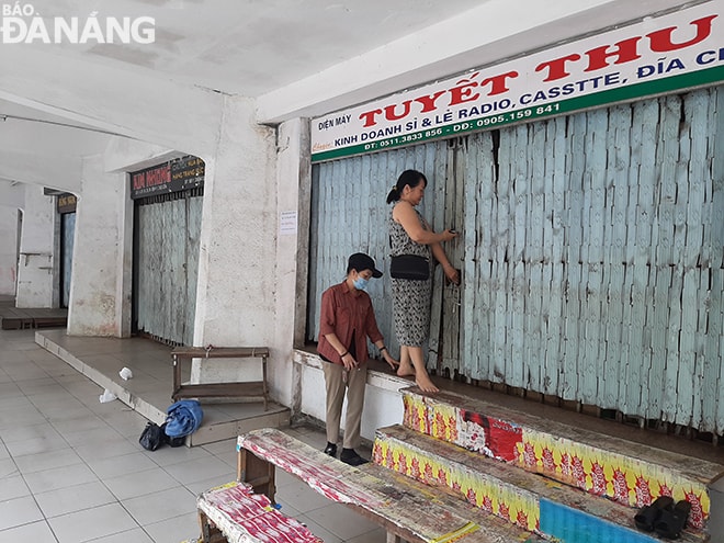 Bà , tiểu thương kinh doanh tại chợ Cồn cho biết, sáng 1-4, ngay sau hướng dẫn của Ban quản lý chợ, bà đã thực hiện ngay việc thu dọn và tạm đóng cửa quầy hàng. Ảnh: KHÁNH HÒA