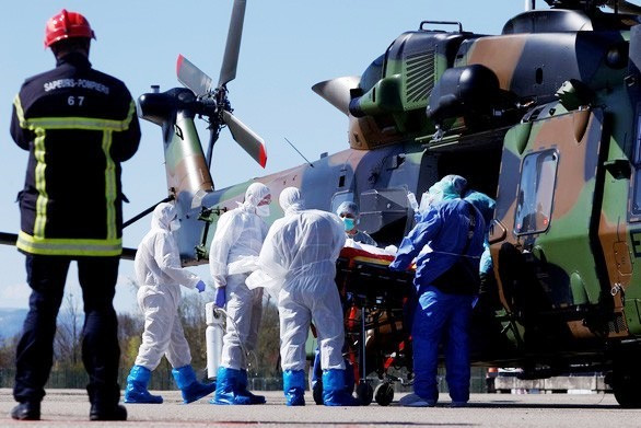 Một người bệnh COVID-19 được khiêng bằng cáng thương lên trực thăng Caiman của quân đội Pháp từ Strasbourg ra nước ngoài điều trị ngày 30/3. Ảnh: Reuters.
