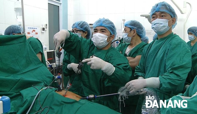 Đề án Bệnh viện vệ tinh giúp giảm áp lực cho tuyến trên. TRONG ẢNH: Chuyển giao kỹ thuật phẫu thuật nội soi cắt túi mật, cắt ruột thừa tại Trung tâm Y tế quận Cẩm Lệ.     Ảnh: PHAN CHUNG