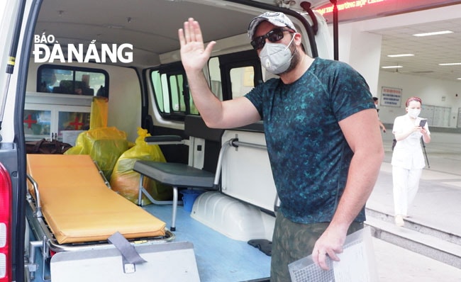 Bệnh nhân vui vẻ vẫy chào nhân viên y tế khi rời bệnh viện. Ảnh: PHAN CHUNG