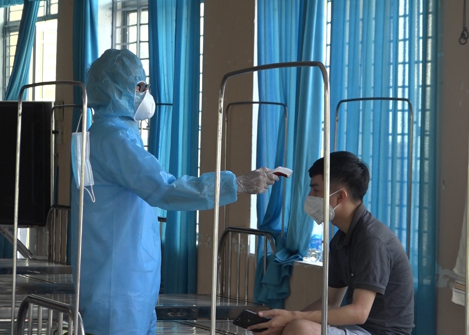 Kiểm tra thân nhiệt tại khu cách ly tập trung của huyện Thăng Bình đặt ởTrạm Y tế thị trấn Hà Lam. Ảnh: GIANG BIÊN