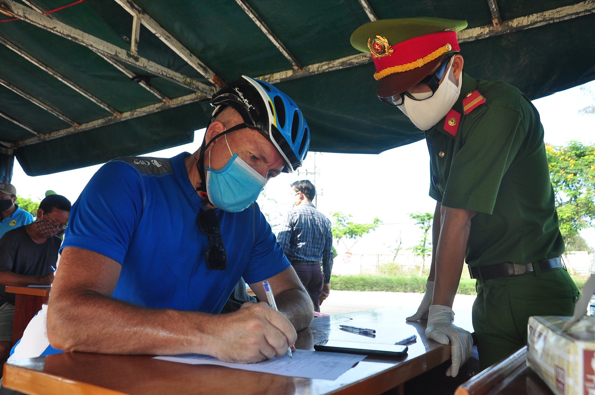 Du khách này là ông Michel Gemain, người Canada, làm việc tại TP.Đà Nẵng, tham gia khai báo y tế tại chốt kiểm soát. Ảnh: V.A