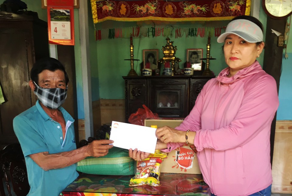 Đại diện Ủy ban MTTQ Việt Nam xã Duy Phước trao tiền và quà hỗ trợ cho người bán vé số trên địa bàn xã.