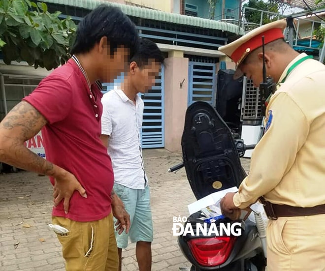 Công an quận Liên Chiểu xử lý một trường hợp người điều khiển xe không đội mũ bảo hiểm. Ảnh: T.YẾN